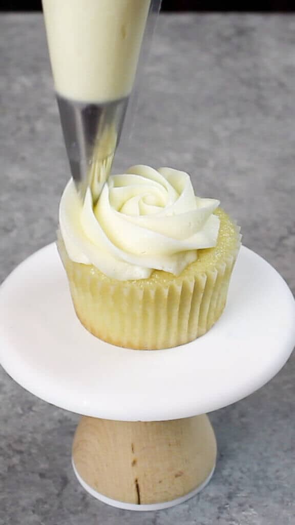 Image of piping a buttercream rosette onto a cupcake using a Wilton 1M frosting tip