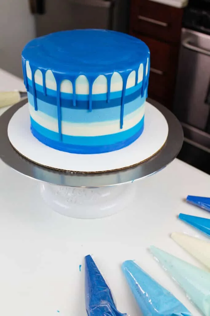 image of blue striped cake with a blue drip