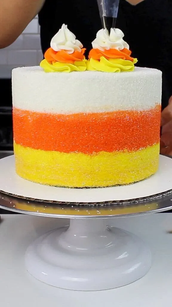 image of piping frosting on top of the cake with a wilton 1M frosting tip