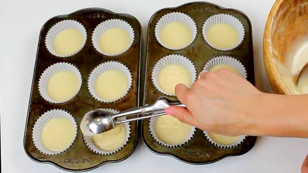 image of scooping vanilla cupcake batter into liners