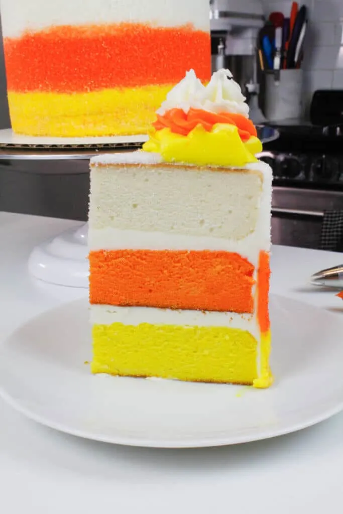image of candy corn cake slice, with yellow, orange, and white cake layers
