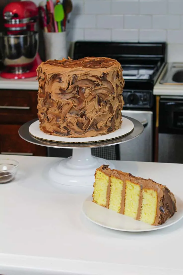 image of the best yellow cake recipe, sliced and frosted with chocolate buttercream