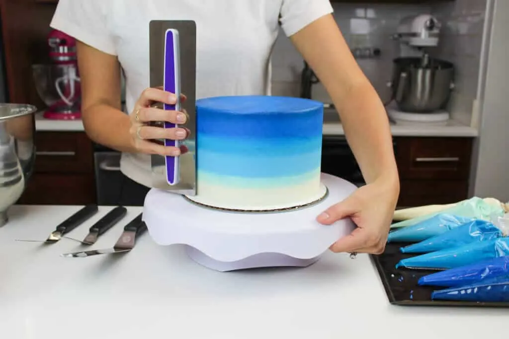 image of smoothing ombre blue frosting onto a layer cake
