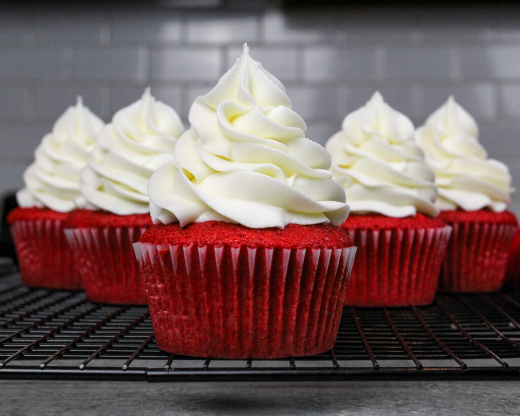 image of red velvet cupcake frosted with a giant swirl of cream cheese frosting