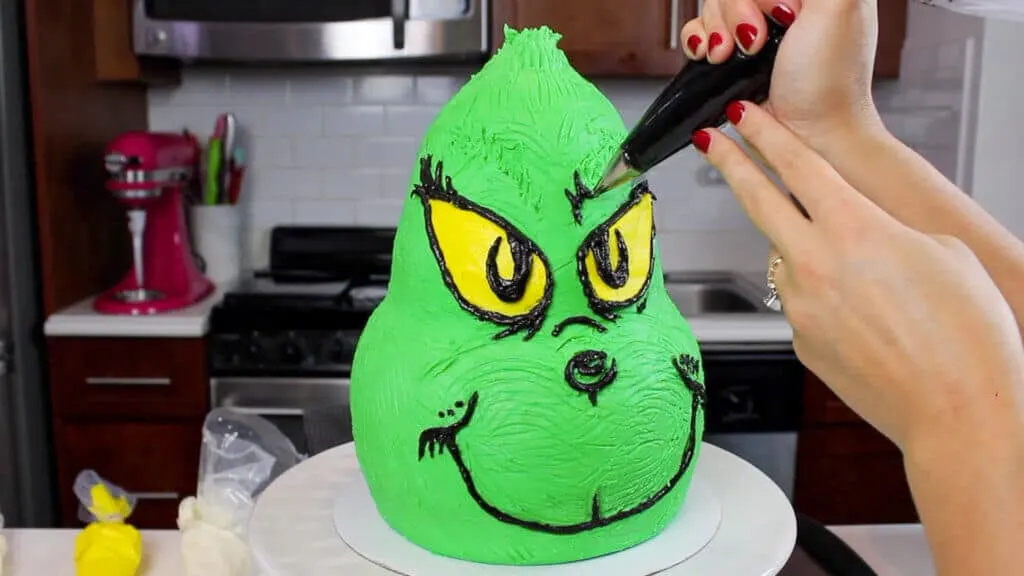 image of piping Grinch's face on with buttercream