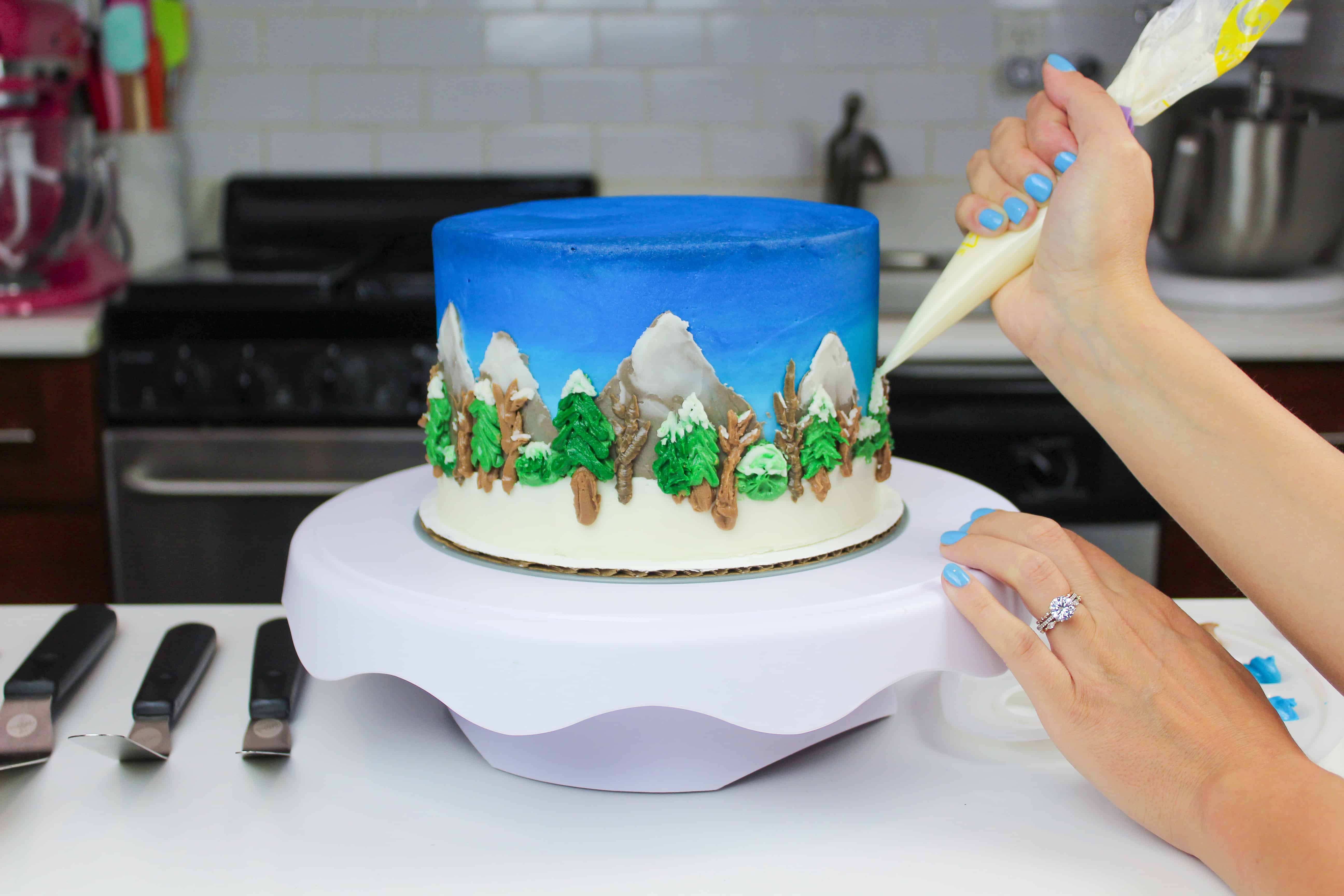 image of american buttercream being piped onto a detailed winter wonderland cake