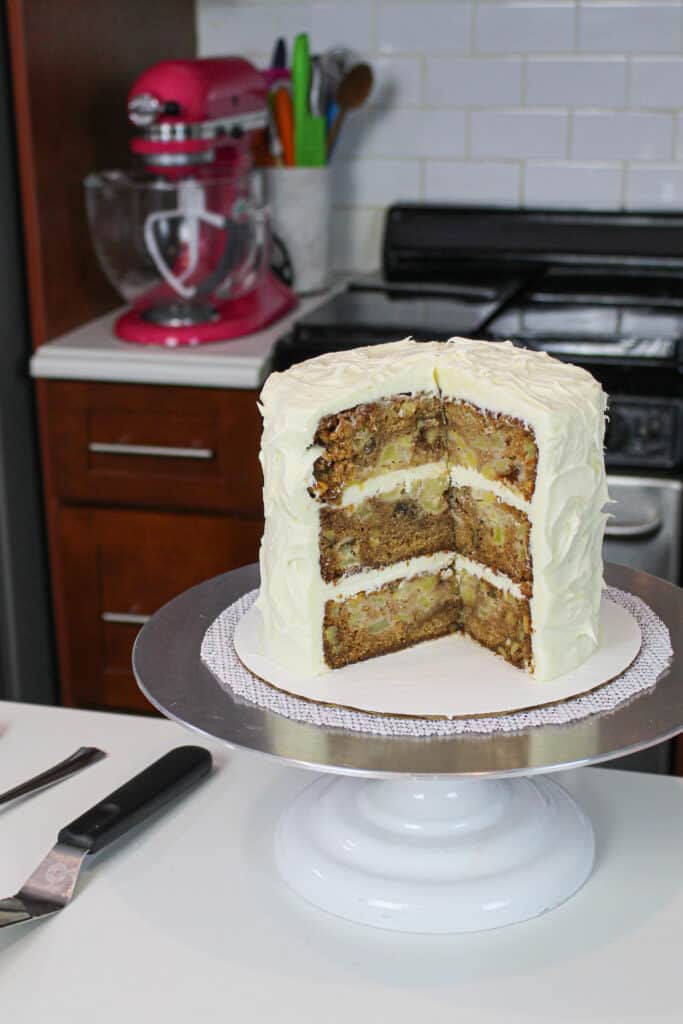 image of sliced into old school apple cake, frosted with cream frosting