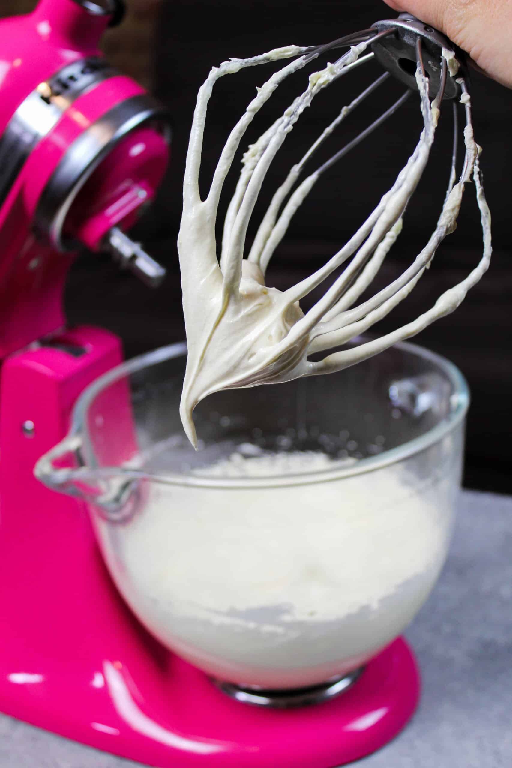 image of buttercream frosting on whisk attachment in front of stand mixer