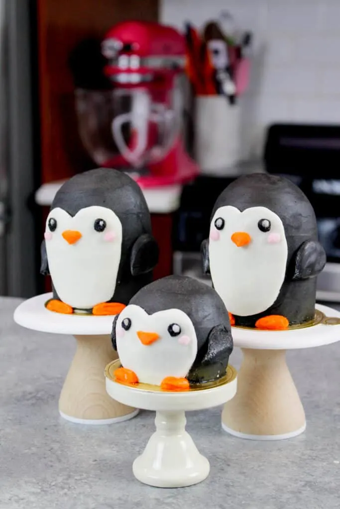image of penguin cupcakes on mini pedestals, positioned to look like a little penguin family
