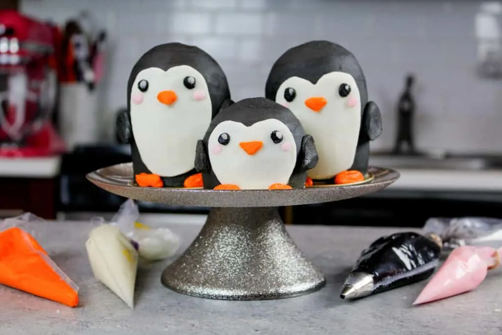 image of penguin cupcakes on cake stand with frosting bags around them
