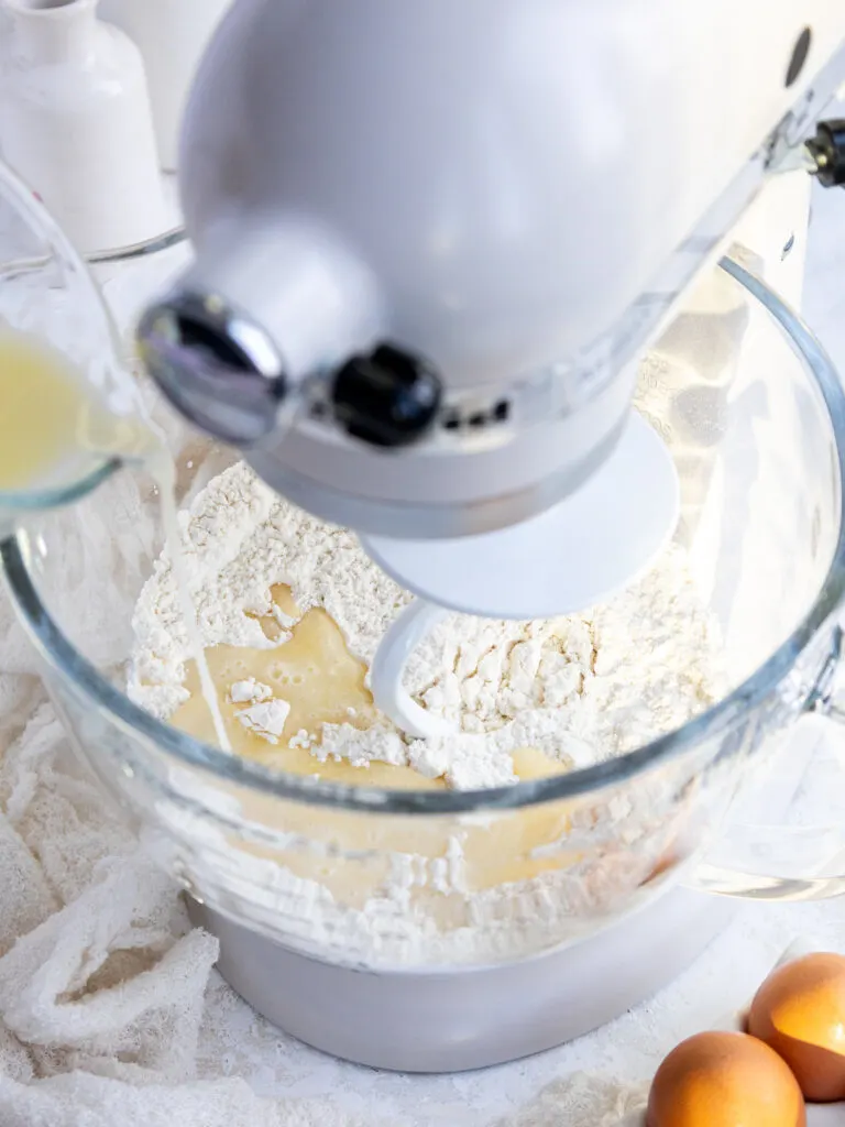 image of wet ingredients being added into dry ingredients to make quick yeast cinnamon roll dough