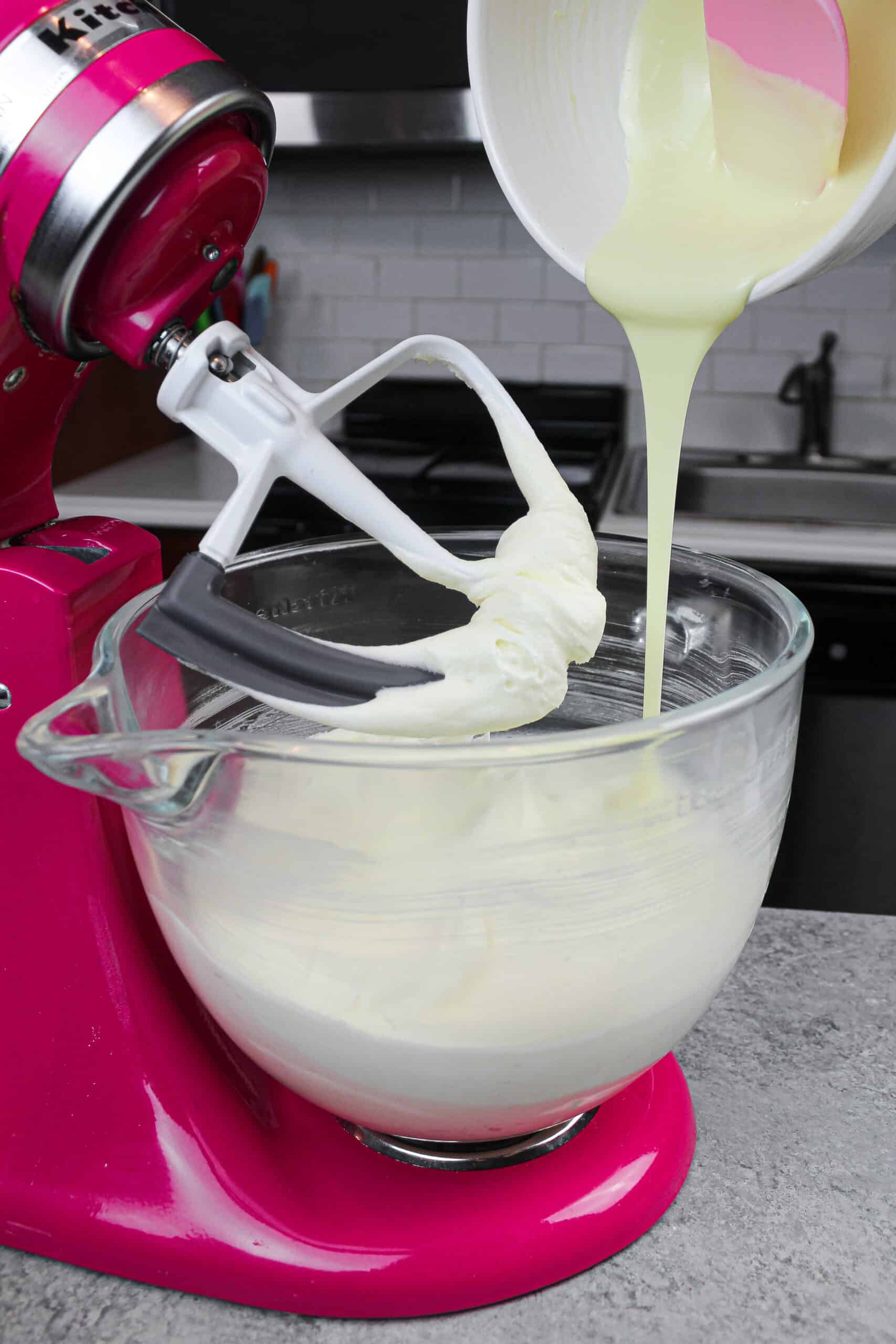 image of melted white chocolate being added into american buttercream to make white chocolate frosting