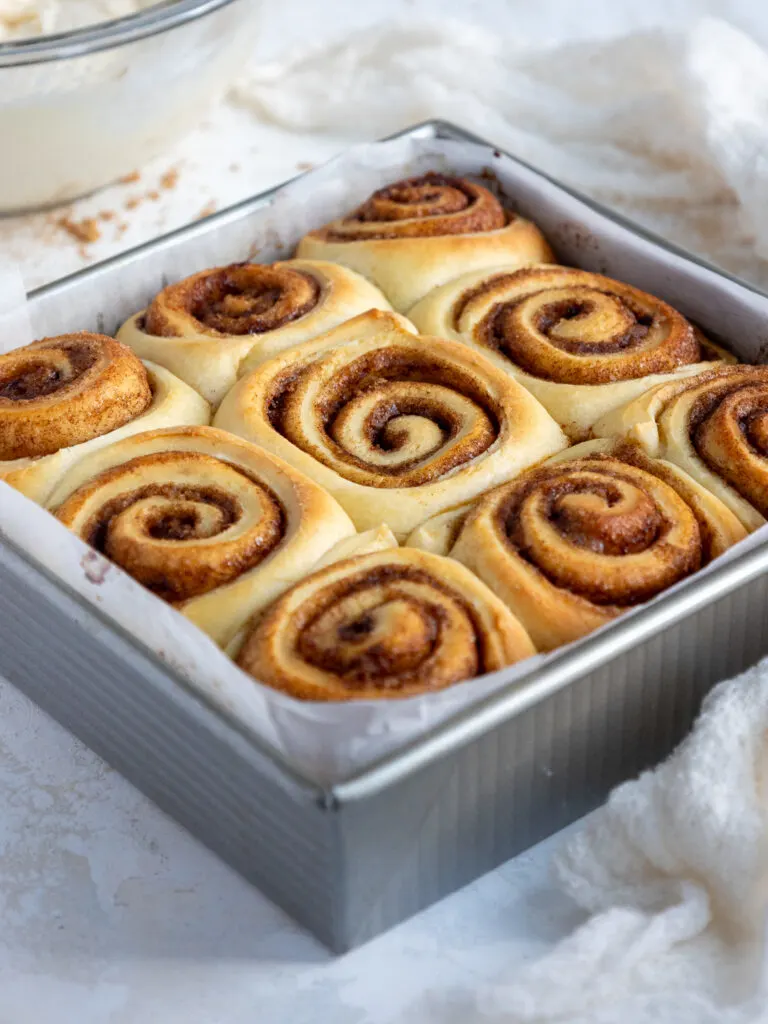 image of quick yeast cinnamon rolls that have been baked and are cooling off in the pan