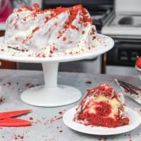 image of red velvet bundt cake, sliced with a cream cheese glaze icing
