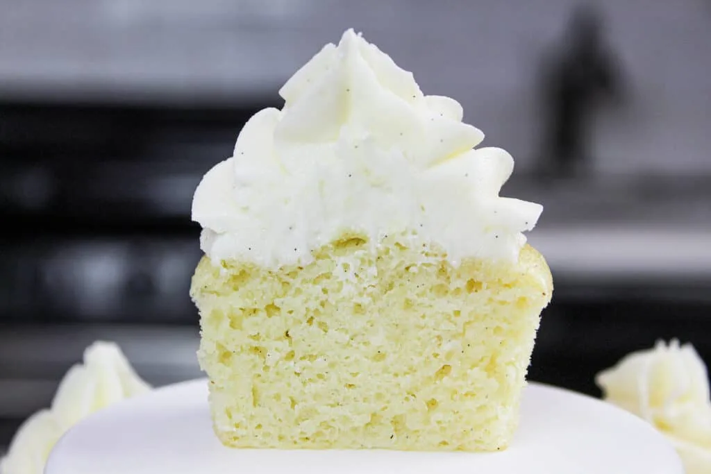 image of a gluten free vanilla cupcake cut in half, to show how moist and fluffy the cupcake is