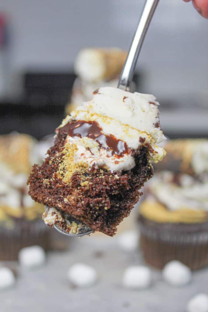 photo of a spoonful of a smores cupcake, showing the marshmallow filling and vanilla buttercream
