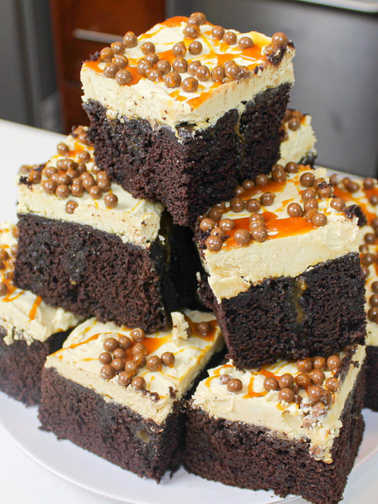 image of slices of chocolate caramel poke sheet cake stacked on a plate