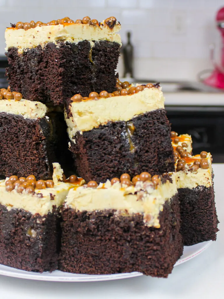 image of pieces of chocolate caramel poke cake stacked on a plate