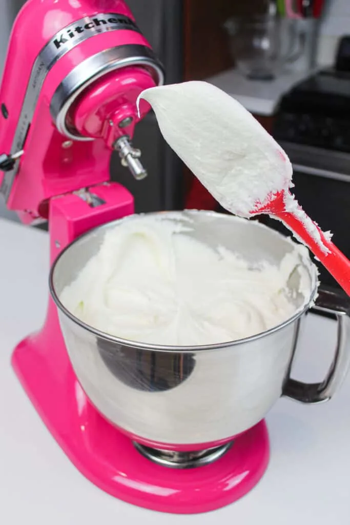 image of vanilla bean buttercream frosting being tested for the right consistency
