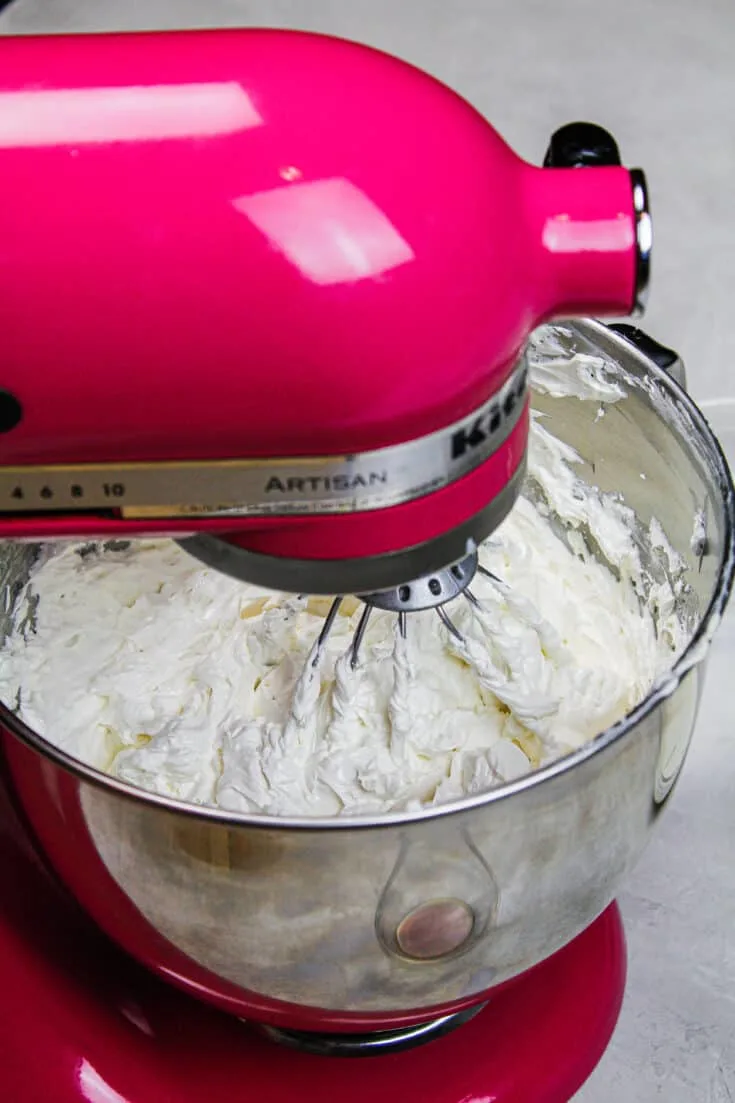 image of siwss meringue buttercream being made in a kitchen aid stand mixer