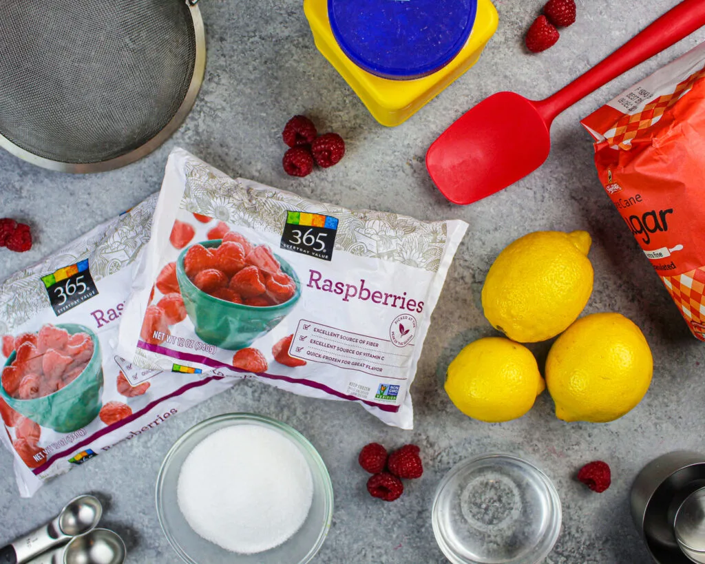 image of the ingredients used in this raspberry cake filling including frozen raspberries, sugar, and lemon juice