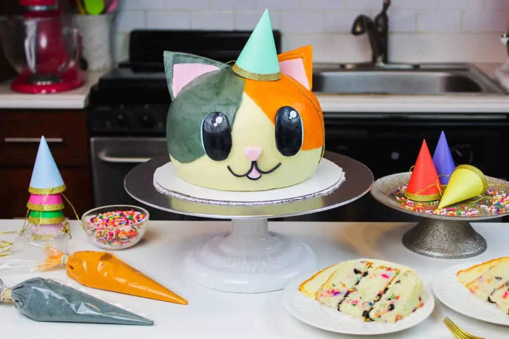 image of cat cake made by chelsweets with cute party hat on
