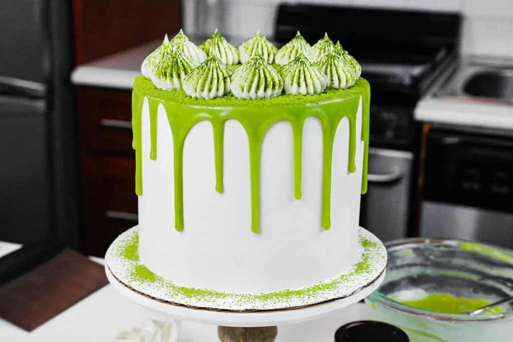 image of a matcha cake with fluffy buttercream frosting dusted in matcha powder