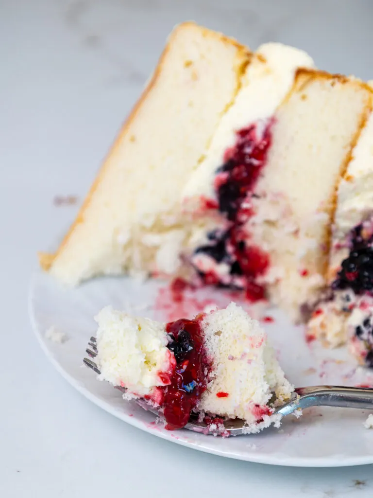 image of a bite of berry chantilly cake on a fork