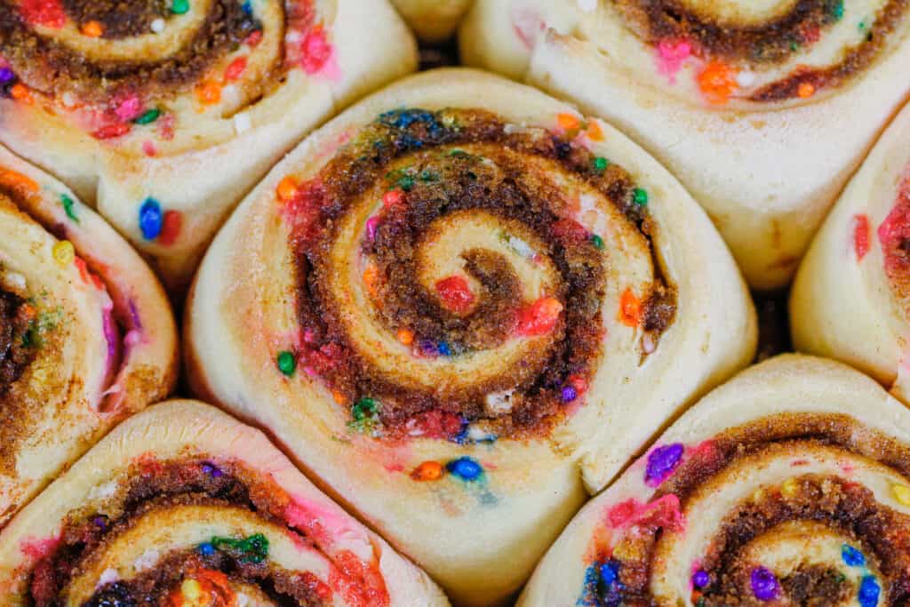 image of funfetti cinnamon rolls baked and cooling before adding sprinkles and frosting
