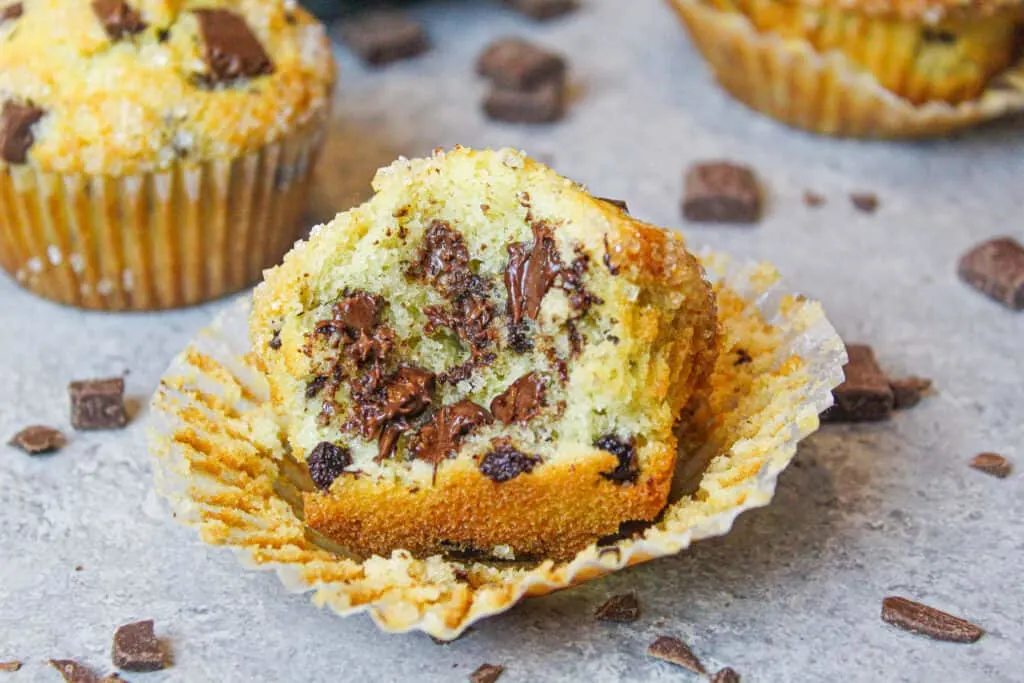 image of chocolate chip muffin that's been bitten into to show how fluffy and tender it is
