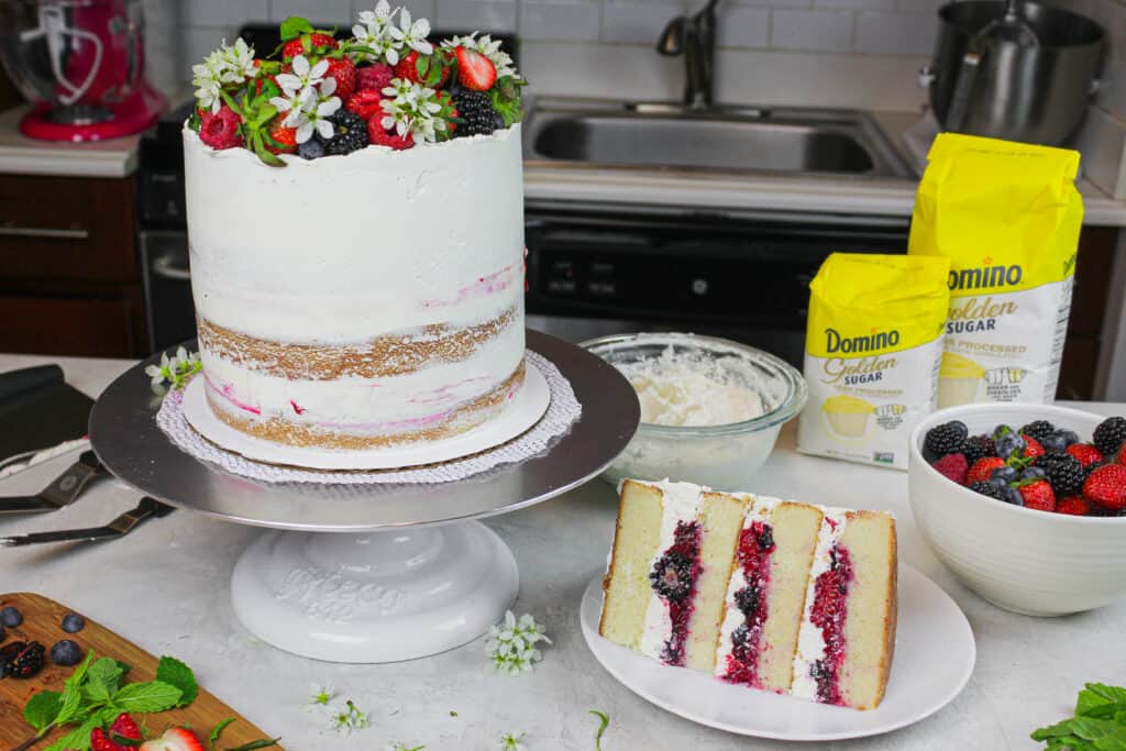image of berry chantilly cake with slice cut out to show berry filling