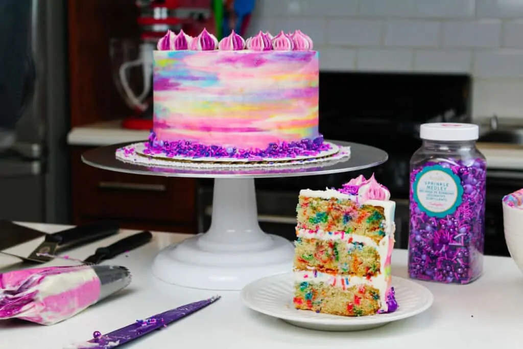 image of vegan confetti cake slice and frosted cake for a birthday