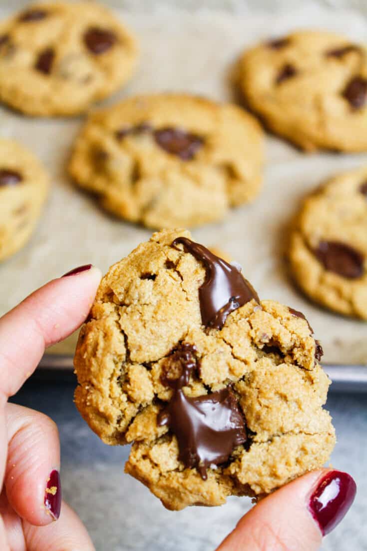 image of 5 Ingredient Peanut Butter Cookie held in hand to show melting chocolate and flakes of sea salt