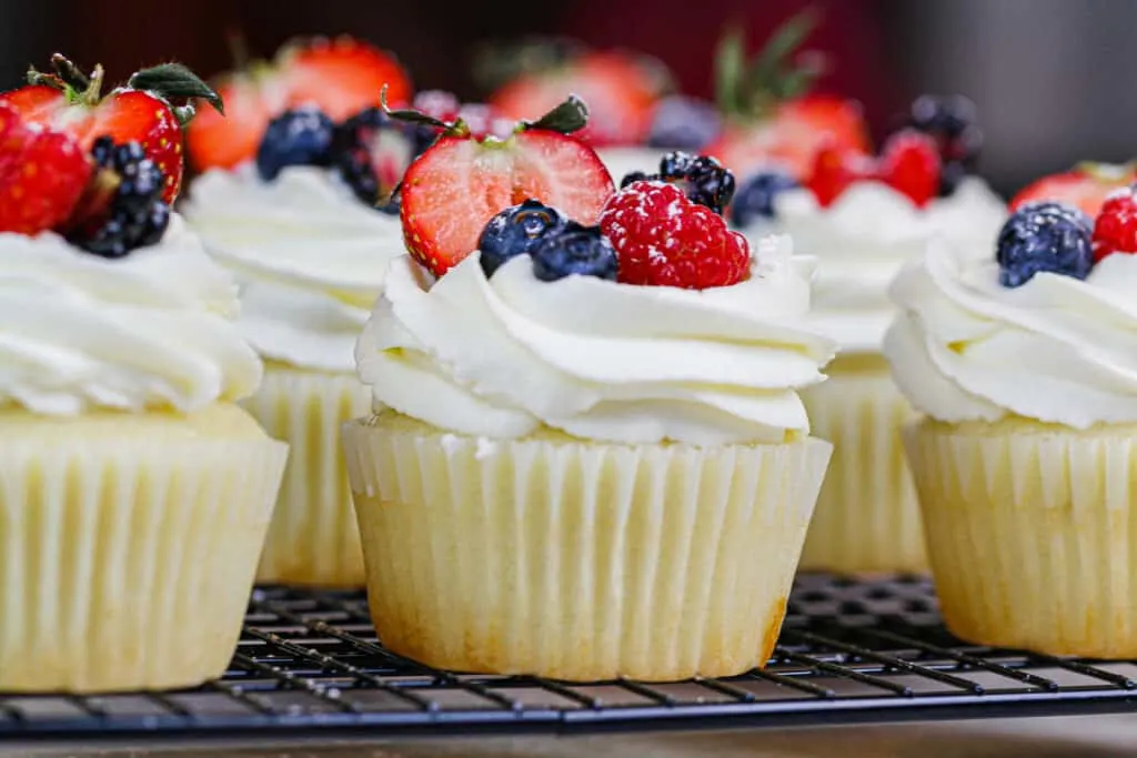 image of cupcakes topped with whipped cream frosting and fresh fruit