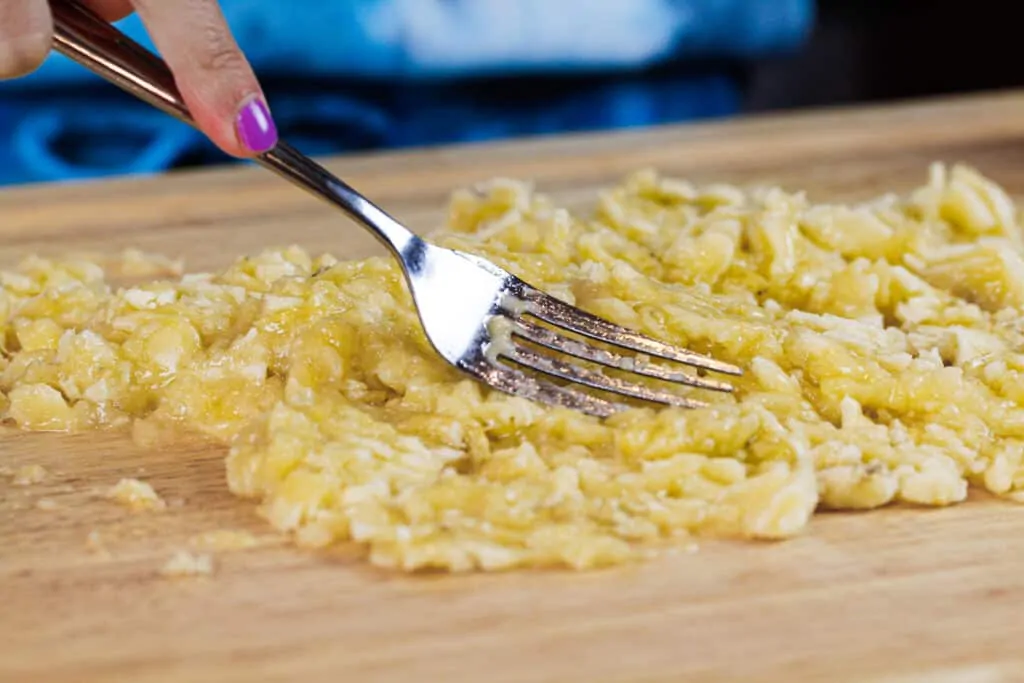 image of bananas being mashed with a fork to make banana bread which make a great substitution for eggs