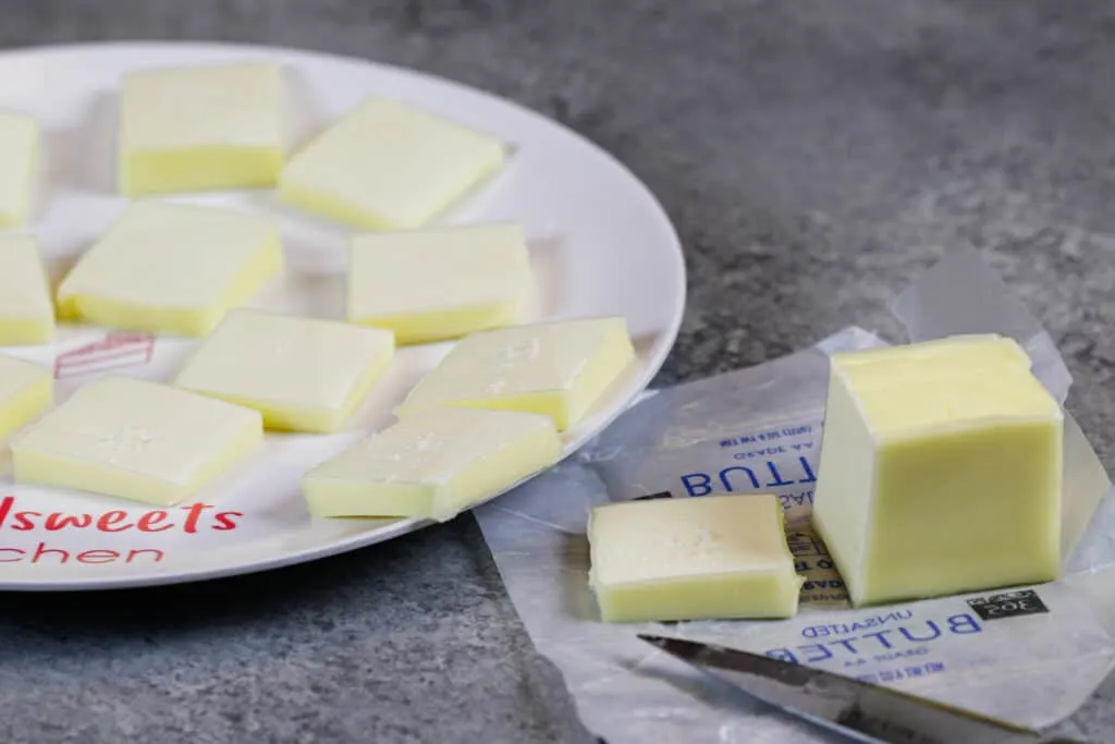 image of unsalted butter cut into small pieces to help it come to room temperature more quickly, shared as part of a baking substitutions guide with lots of substitutions for butter and oil