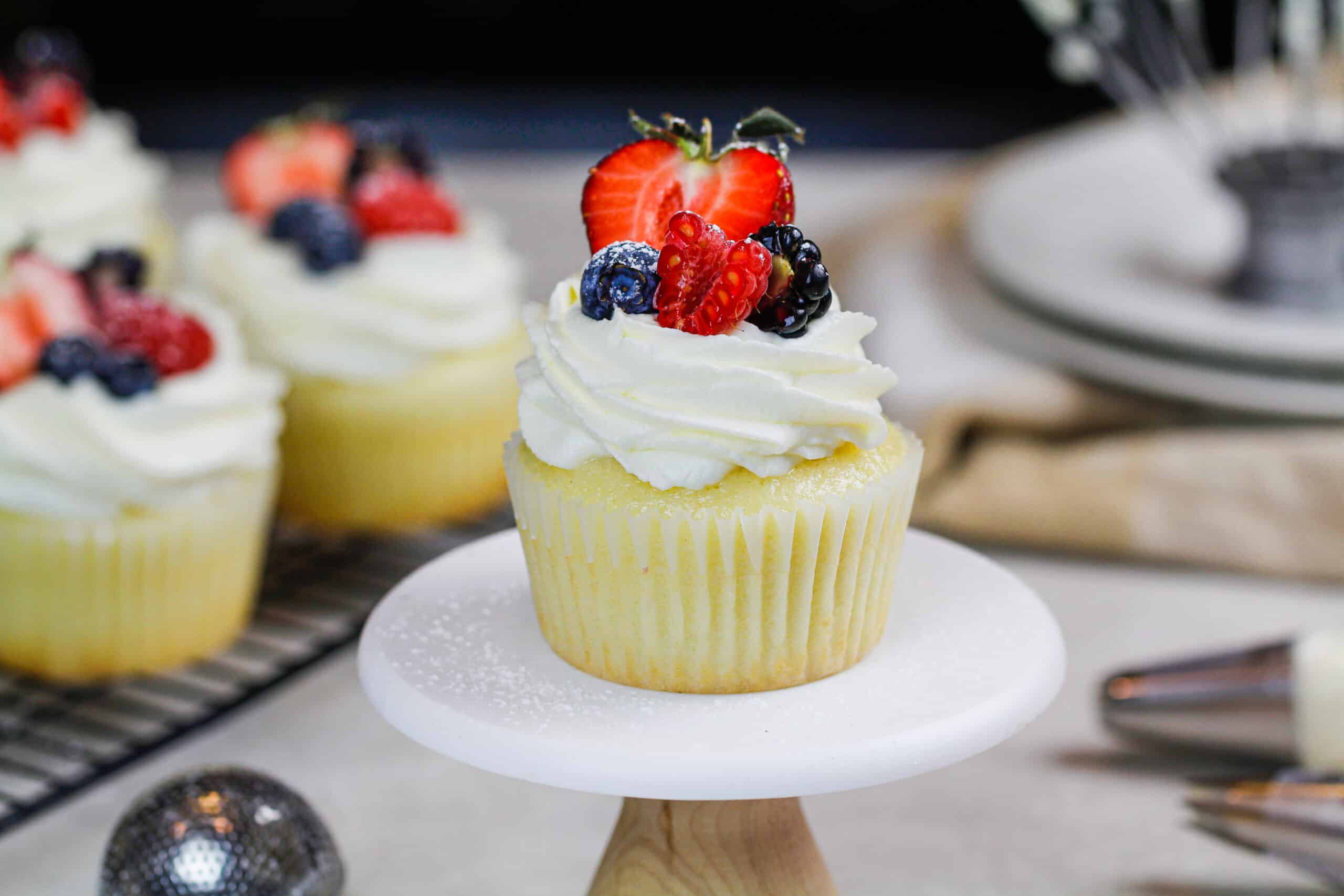 image of cupcakes topped with whipped cream frosting and fresh fruit