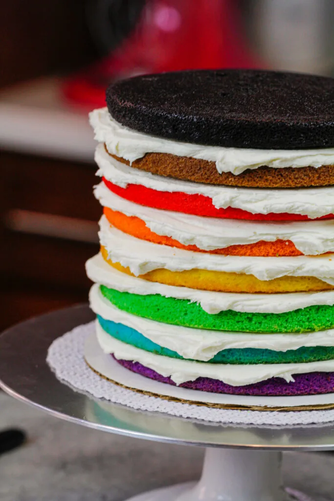 image of 8 color inclusive rainbow cake layers stacked and ready to be crumb coated for pride