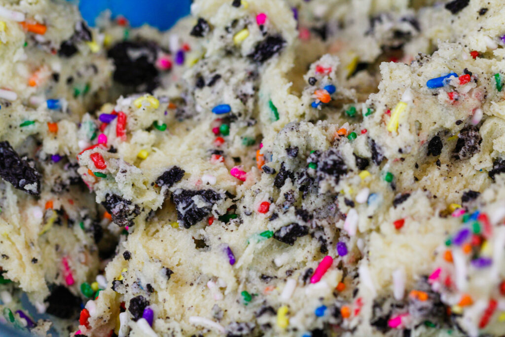 image of funfetti oreo cookie dough up close to show all the crushed oreos and sprinkles.