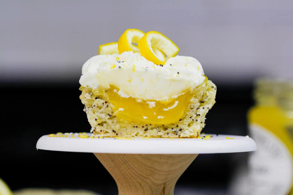 image of lemon poppy seed cupcake cut in half to show lemon curd filling