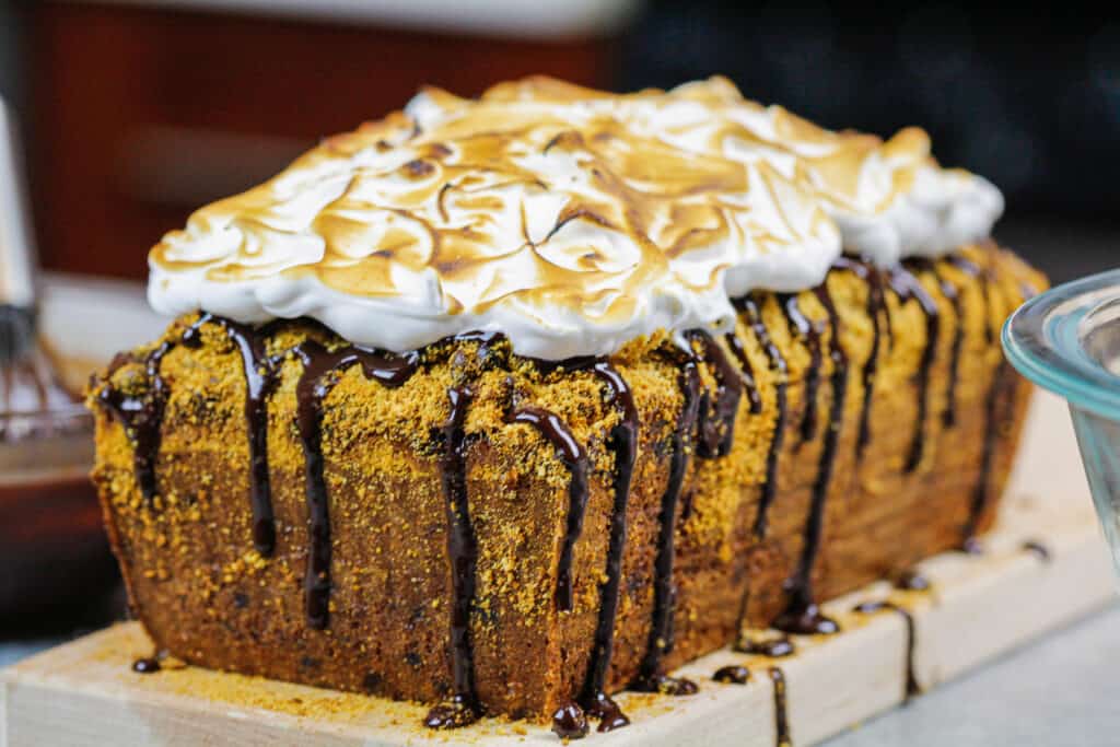 image of smores banana bread decorated with a chocolate drizzle and toasted marshmallow topping