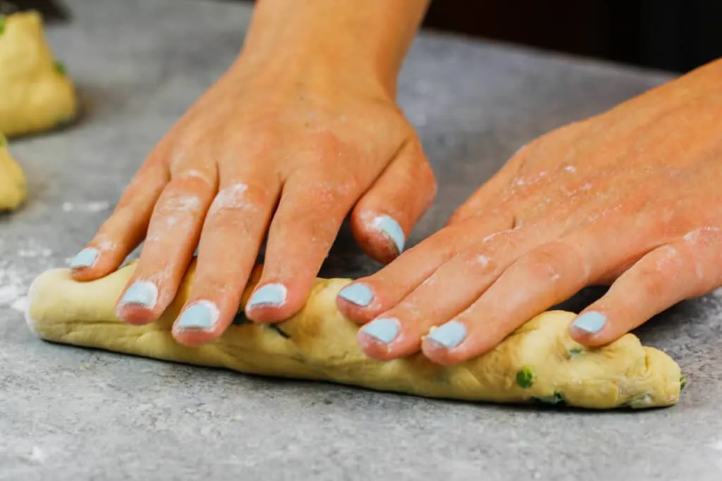 image of jalapeno cheddar bagels being rolled out to be formed into a bagel
