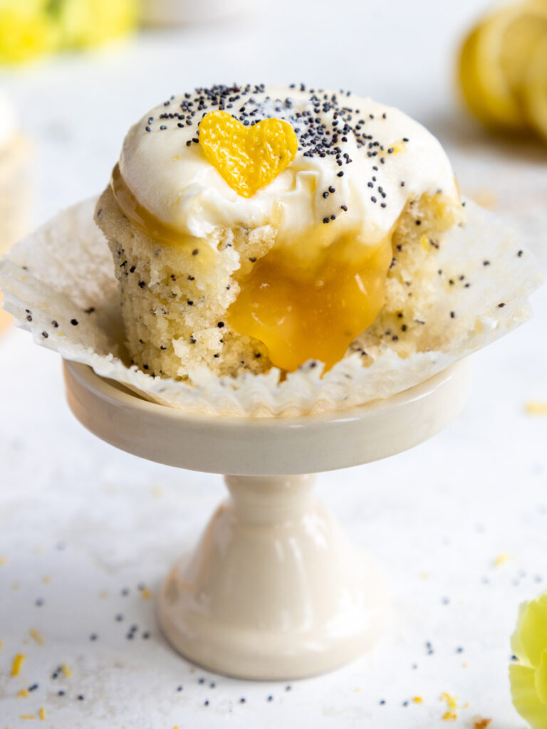 image of a delicious lemon poppy seed cupcake that's been cut into to show its lemon curd filling