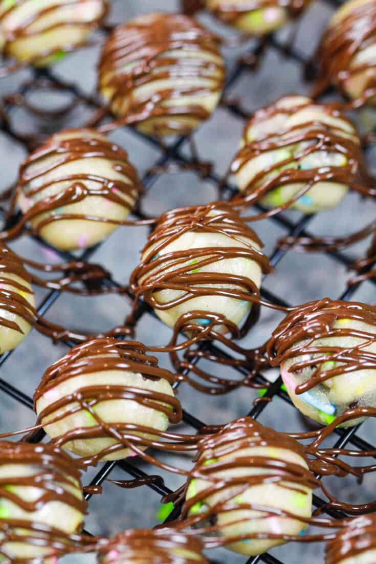 image of cookie dough bites on a wire rack that have been drizzled with melted chocolate