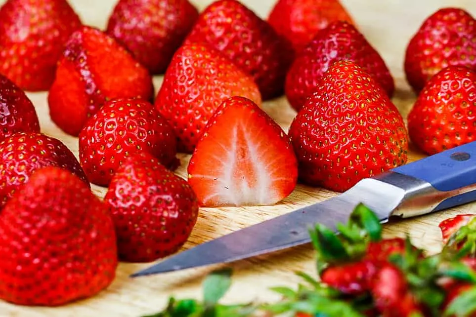 image of strawberries being hulled and cut
