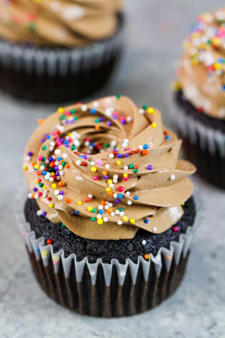 image of chocolate italian meringue buttercream frosting piped onto chocolate cupcakes