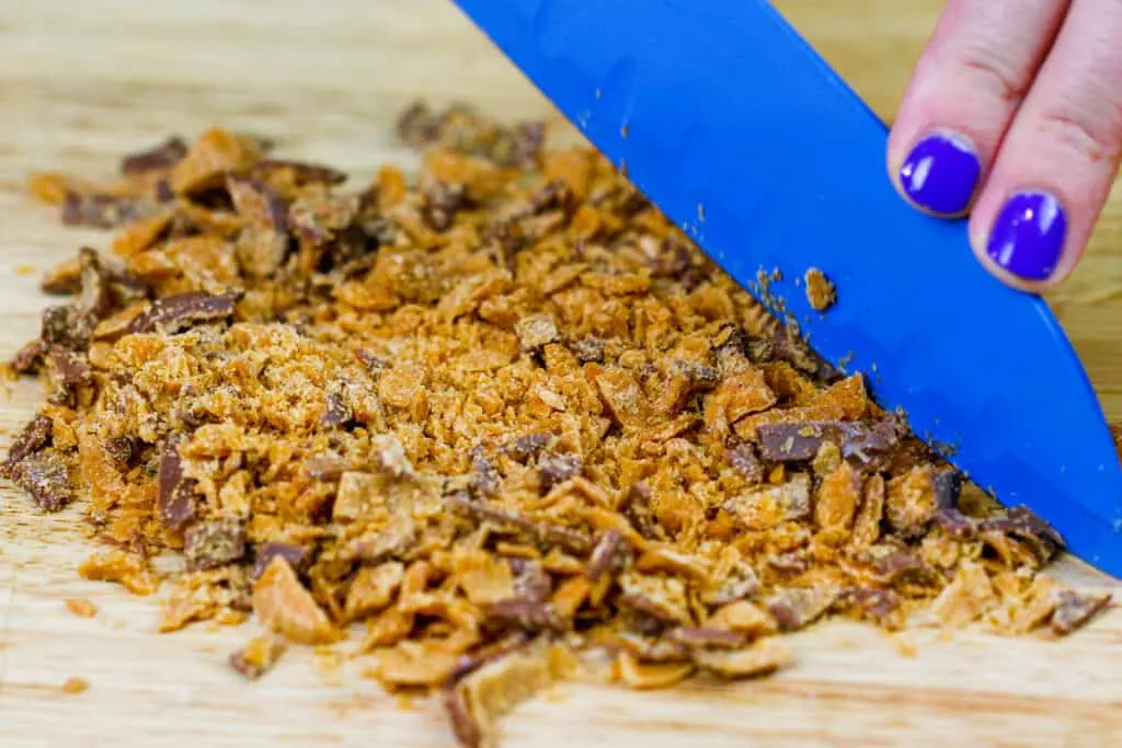 image of butterfinger bar being chopped up to make monster butterfinger cookies