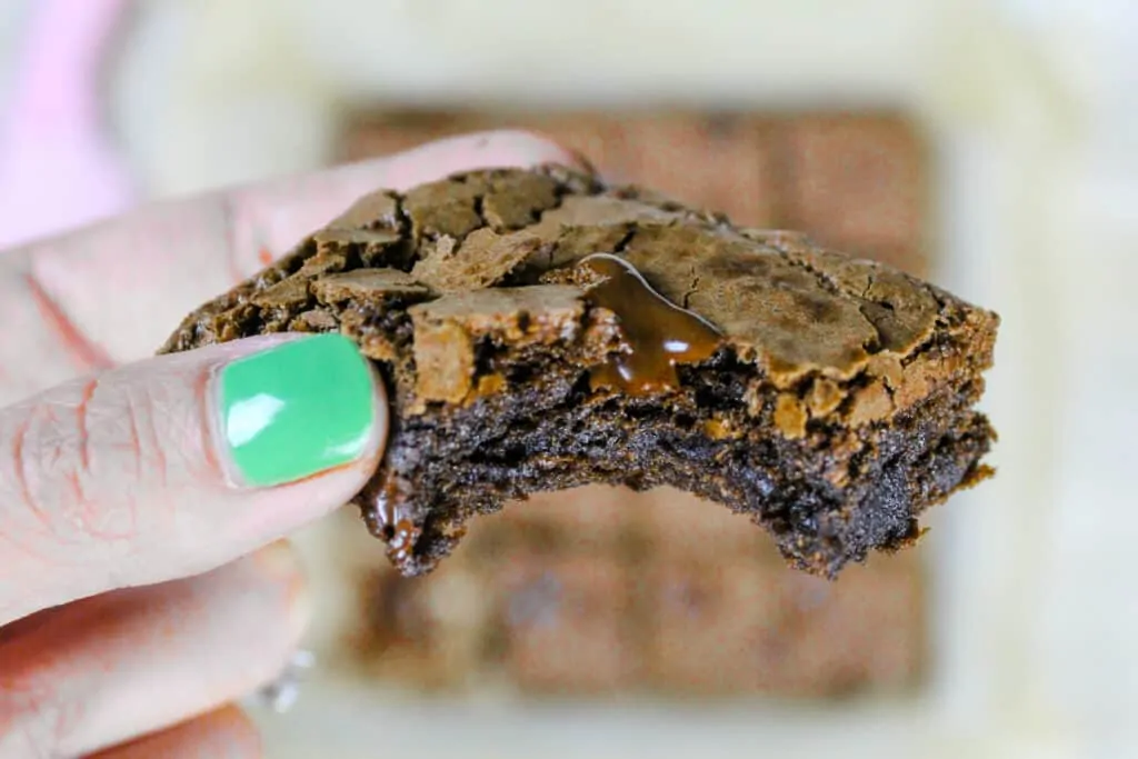 image of a dairy free brownie being held in the air to show how chewy and fudgy it is