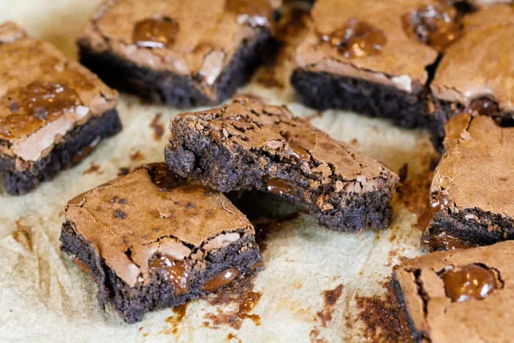 image of dairy free and eggless brownies cut into squares on parchment paper