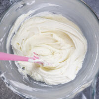 image of vanilla American buttercream in bowl that's been stirred with a spatula to make it super smooth
